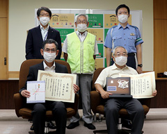 【写真】秋葉区交通安全協会の今井さん（前列左）、秋葉区交通安全協会北上支部代表渡辺さん（前列右）と夏目区長（後列左）、秋葉区交通安全協会鬼島会長（後列中央）、秋葉警察署齋藤交通課長（後列右）