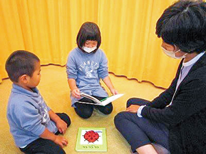 男の子と女の子に読み聞かせをしている写真