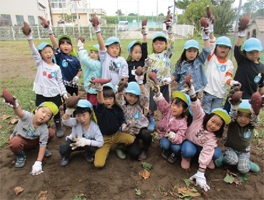 サツマイモを持ち上げた根岸保育園の子どもたちの集合写真