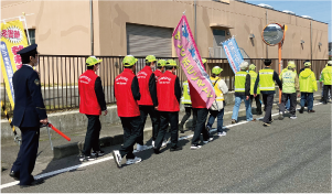 白根高校の生徒が「日の出町防犯パトロール」に参加し、他の参加者と一緒にヤングボランティアののぼり旗を持って歩いている写真
