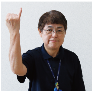 手話通訳者・鈴木さんが小指を立てて高く上げている写真