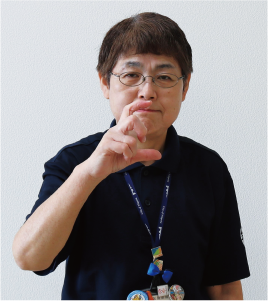 手話通訳者・鈴木さんが曲げた人差し指と親指で「日」を形作っている写真