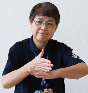 手話通訳者・鈴木さんが片方の手は甲を上にして、その上に反対の手の平を縦にして乗せている写真