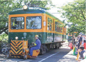 かぼちゃ電車保存会のメンバーが鉄道車両用車両移動機「アント」を運転し、かぼちゃ電車を動かしている写真