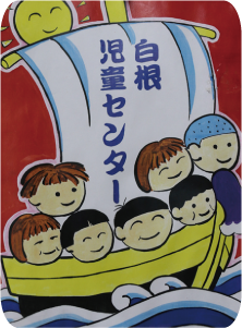 帆に「白根児童センター」と書かれ、笑顔の男女の子どもたち複数人が乗った宝船の絵柄の大凧の写真