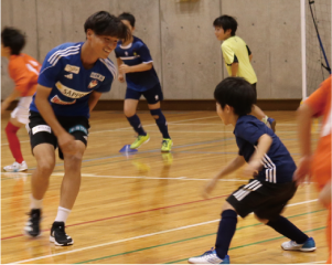 石山選手が子どもとサッカーをする写真