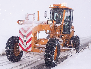 除雪車が積雪のある道路を除雪している写真