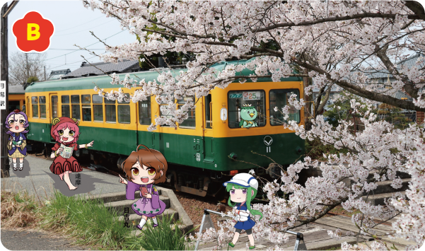 満開の桜の木の奥にかぼちゃ電車、運転士席にはみなみく妖怪大図鑑のかっぱのるいくん。線路を渡る謙信、その前にスマートフォンを片手に指さしながら歩く日吉丸。「月潟駅」の表示が付けてあるプラットホームの電信柱脇でメモを執る弁慶、その前を観光マップ片手に指さしながら歩く達摩の写真。