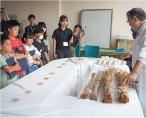 大鷲小学校5年生が新潟大学特任教授・三ツ井敏明さんから説明を受けている写真